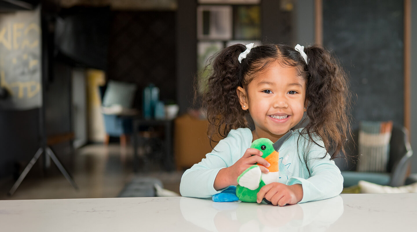 child with stuffed hummingbird toy