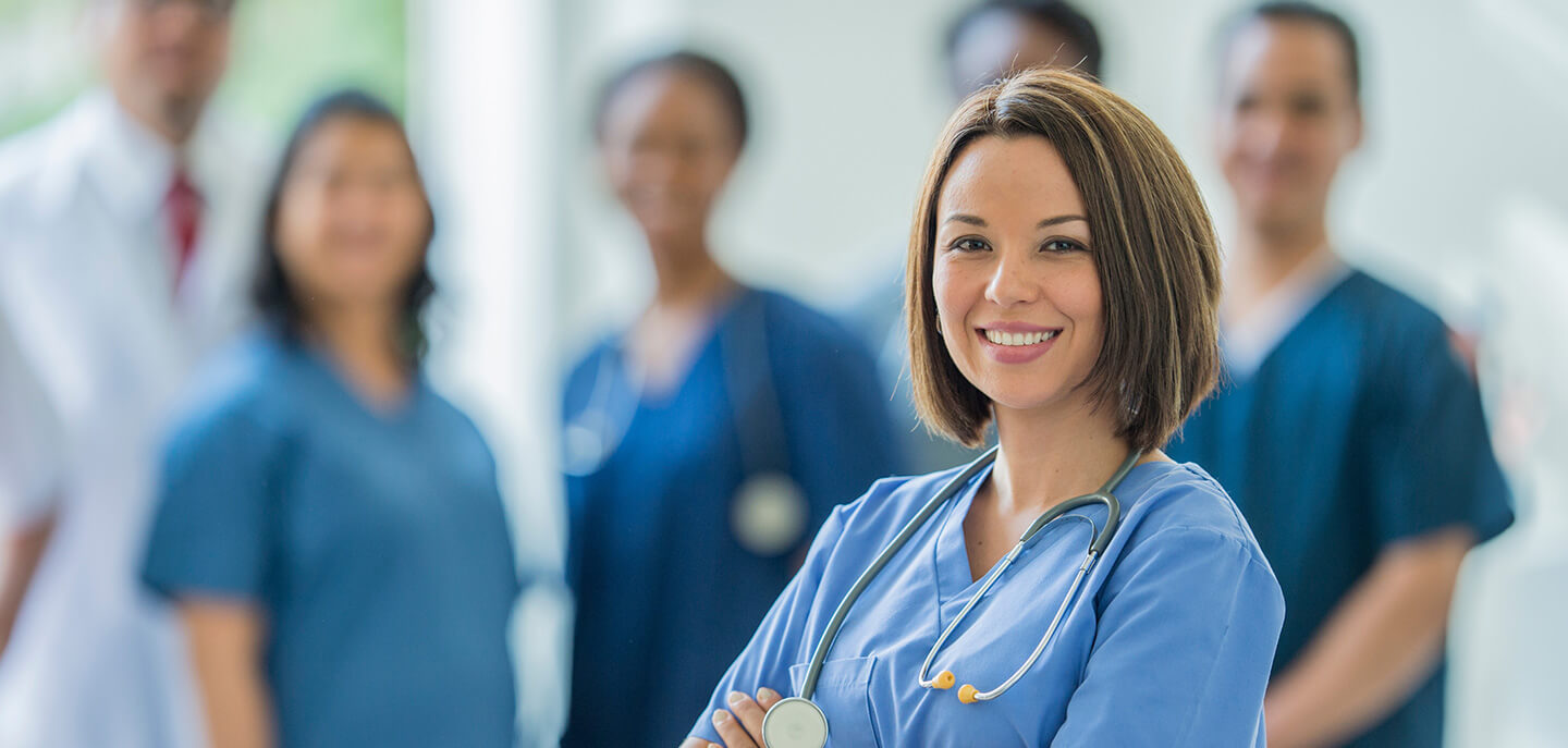 smiling physician in front with 5 others in the back