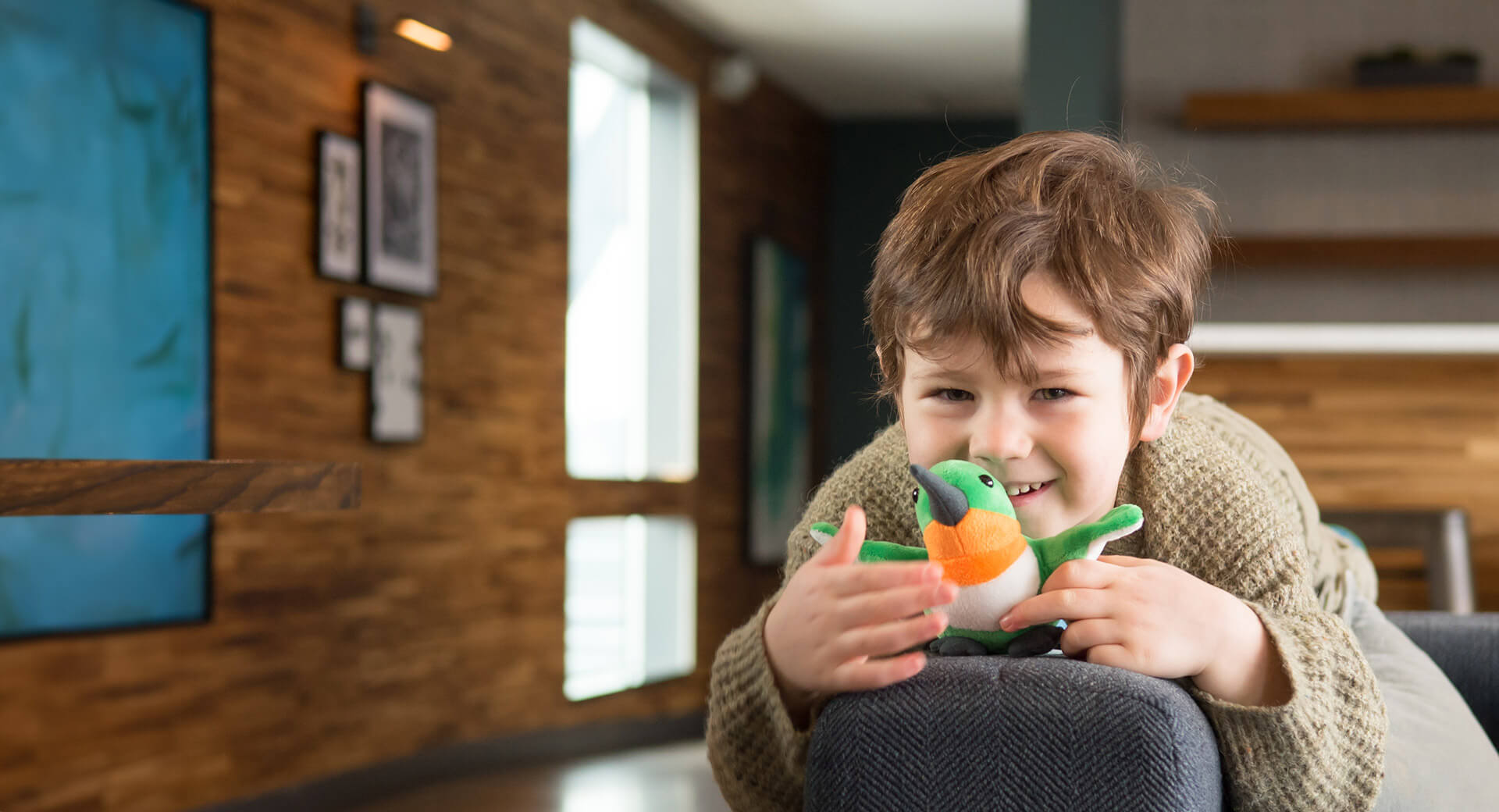 child with stuffed hummingbird toy