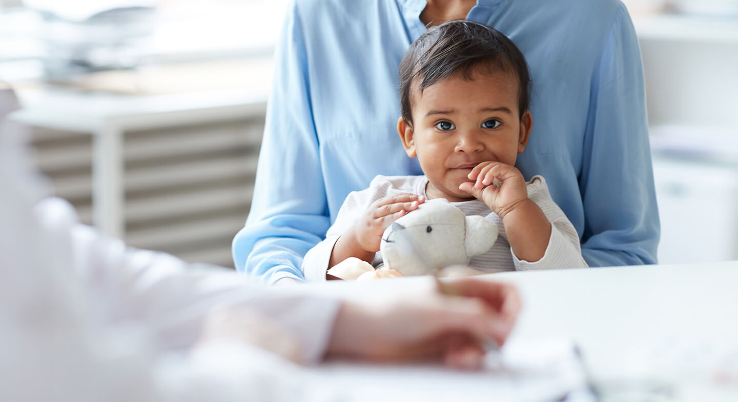 parent holding child on lap at physician's office